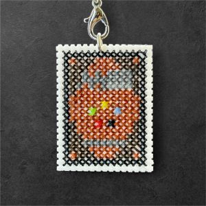 Amuleto bordado a punto de cruz inspirado en una carta de Magic