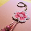 Amuleto bordado a punto de cruz con flor de cerezo rosa hecho a mano