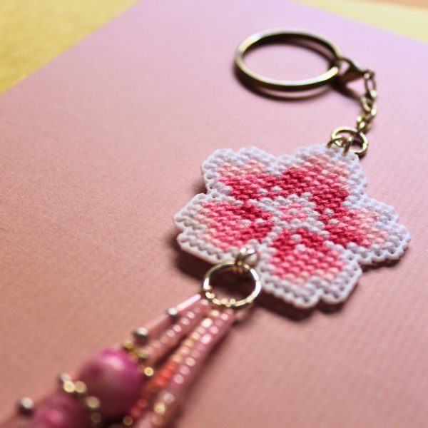 Amuleto bordado a punto de cruz con flor de cerezo rosa hecho a mano