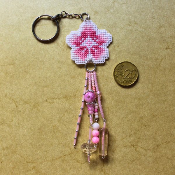 Amuleto bordado a punto de cruz con flor de cerezo rosa hecho a mano