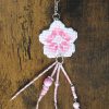 Amuleto bordado a punto de cruz con flor de cerezo rosa hecho a mano