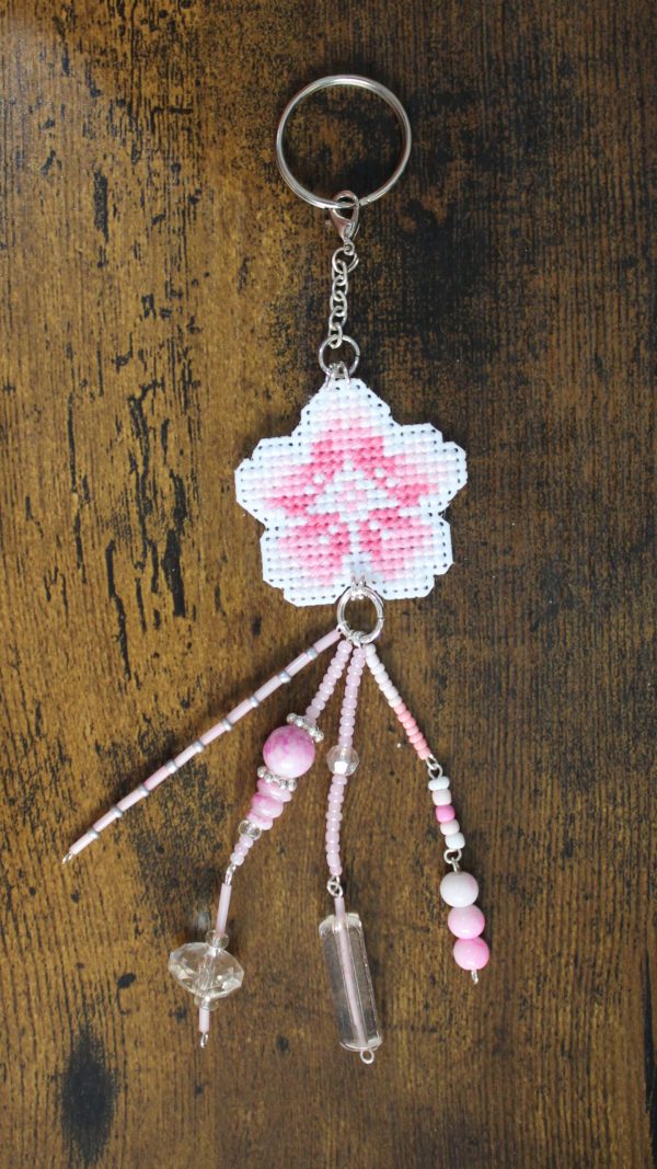 Amuleto bordado a punto de cruz con flor de cerezo rosa hecho a mano