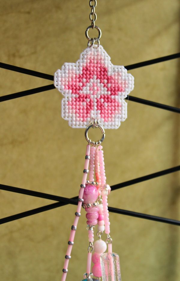 Amuleto bordado a punto de cruz con flor de cerezo rosa hecho a mano