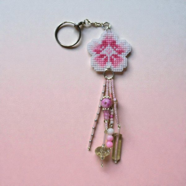 Amuleto bordado a punto de cruz con flor de cerezo rosa hecho a mano