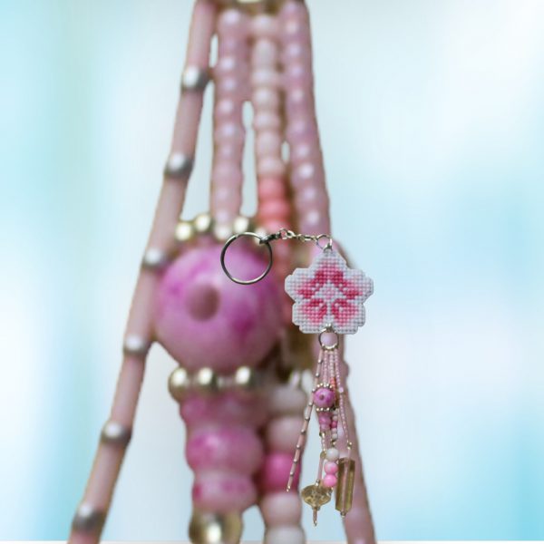 Amuleto bordado a punto de cruz con flor de cerezo rosa hecho a mano